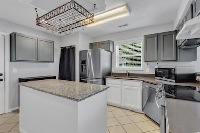 Kitchen with gray cabinets, light tile patterned f