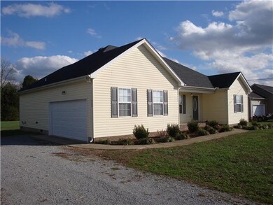 This View shows the Two Car Garage and Mature Shrubbery and Vegetation in Front of the Home.
