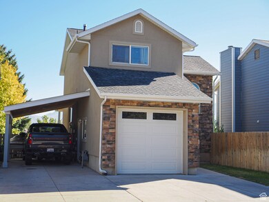 Traditional-style house with stone siding, a carport, and roof with shingles