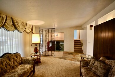 Carpeted living room with stairway