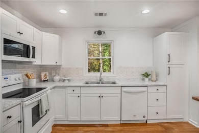 Kitchen featuring white appliances, sink, decorati