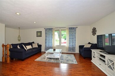 Living room with updated floor, opens to dining ro