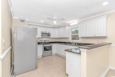 Kitchen featuring kitchen peninsula, appliances wi