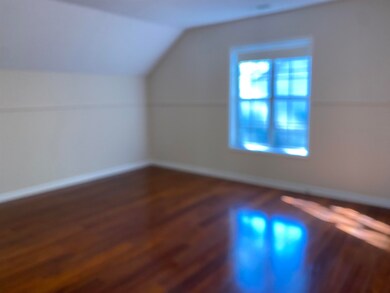 Additional living space with vaulted ceiling and dark wood-style flooring