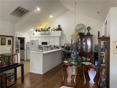 Kitchen with a peninsula, visible vents, white cab