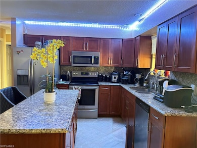 Kitchen with reddish brown cabinets, light tile pa