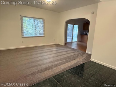 Empty room featuring arched walkways and baseboards