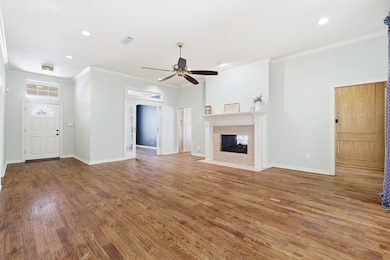 The living room has one of the double fireplaces in this home, wooden floors and lots of space.