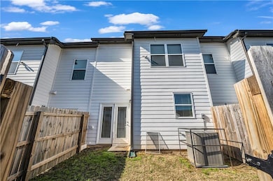 Rear view of house with fence and central air cond