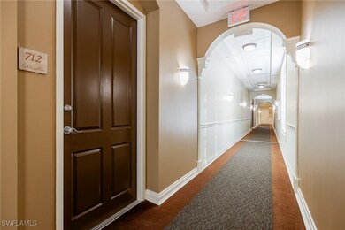 Hall featuring dark colored carpet, baseboards, an