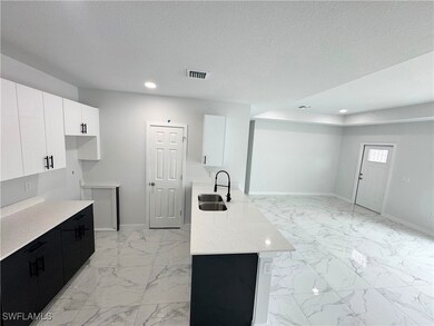 Kitchen featuring dark cabinets, light marble fini