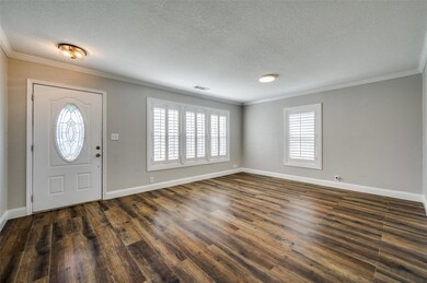 Foyer with dark wood finished floors, a textured c