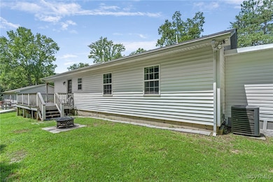 Rear view of house with an outdoor fire pit, a dec