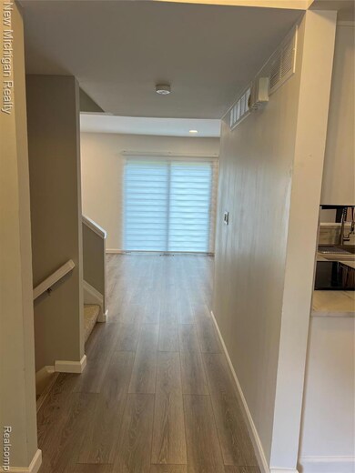 Hallway featuring light wood finished floors and stairs