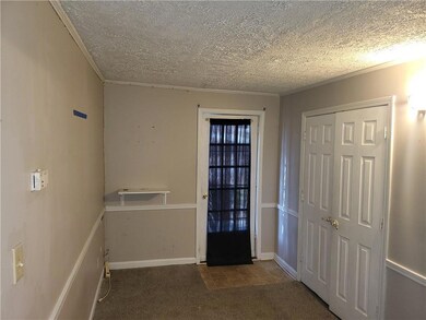 Foyer with carpet floors and a textured ceiling