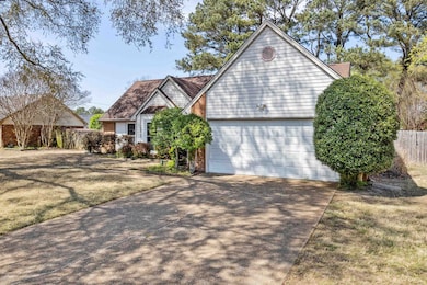 View of front of house with a front yard, an attached garage, fence, and concrete driveway