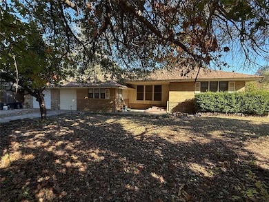 Ranch-style house with brick siding, driveway, and a garage