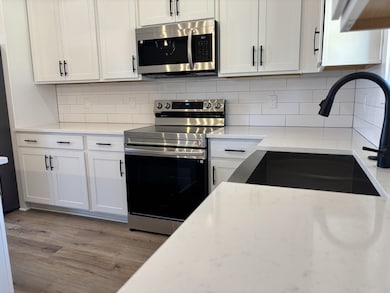 Tile backsplash and quartz counters compliment your chef's kitchen. You have plenty of counters for prepping meals and cabinets for storing food and cooking supplies.