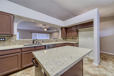 Kitchen featuring a sink, dishwasher, tasteful bac