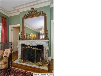 Elegant hand-carved marble mantle below gold-leaf 