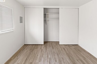 Unfurnished bedroom with wood finished floors, a closet, and electric panel