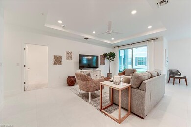 Living area featuring a tray ceiling, a ceiling fan, recessed lighting, and baseboards