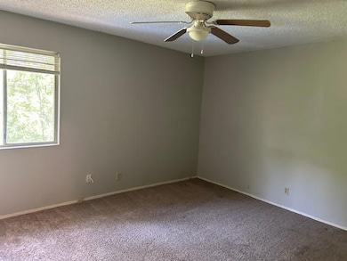 Empty room with a textured ceiling, a ceiling fan