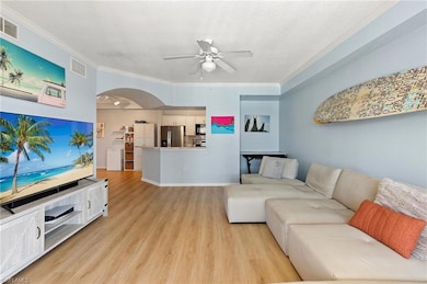 Living room featuring crown molding, light wood-st