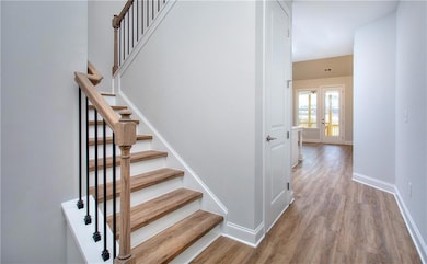 Stairs featuring wood-style finished floors and baseboards