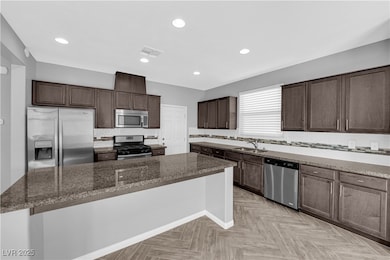 Kitchen featuring stainless steel appliances, a si