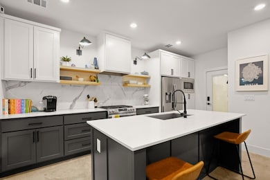 Kitchen with tasteful backsplash, light counterto