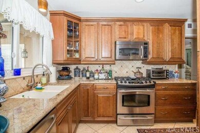 Warm maple window pane cabinets are topped with ne