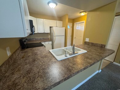 Kitchen with black microwave, a peninsula, a sink,