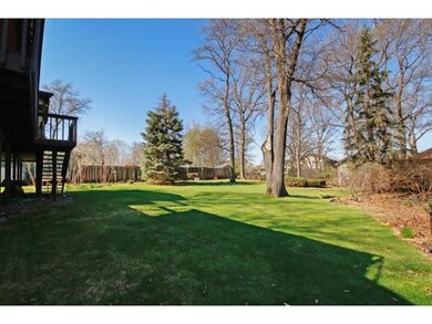 Well maintained backyard with mature trees and gar