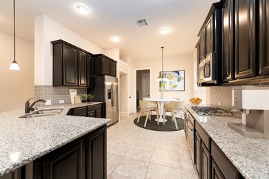 This amazing kitchen is every chef's dream, featuring gorgeous granite countertops, dark stained cabinets, sleek recessed lighting, modern fixtures, and stellar stainless steel appliances!