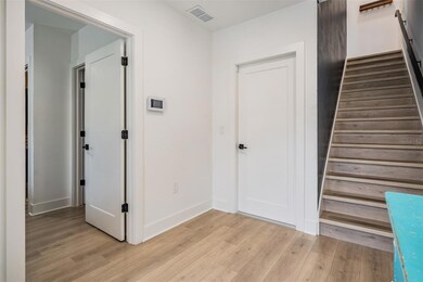 Foyer showing rear garage door entrance, entrance into the downstairs bedroom suite and stairs up to the second floor.