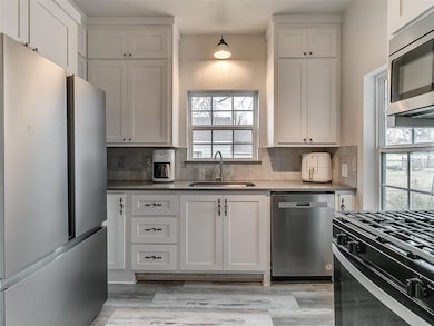 Kitchen with sink, white cabinets, and appliances 