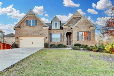 View of front facade with brick siding, concrete driveway, and a garage