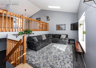 Living room with lofted ceiling with skylight
