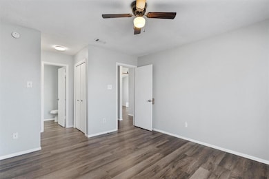 Unfurnished bedroom featuring dark wood-style floors, ceiling fan, and a closet