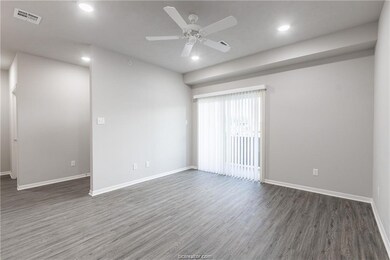Empty room featuring ceiling fan and dark hardwood / wood-style flooring