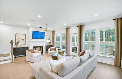 Living area featuring light wood finished floors, a chandelier, recessed lighting, and a fireplace