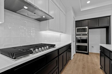 Kitchen with tasteful backsplash, light counterto