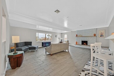 Living area with a brick fireplace, wood tiled flo