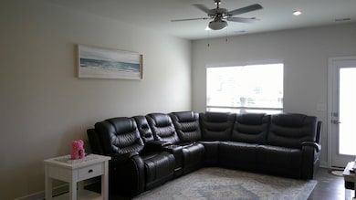 Living room with ceiling fan and dark hardwood / w