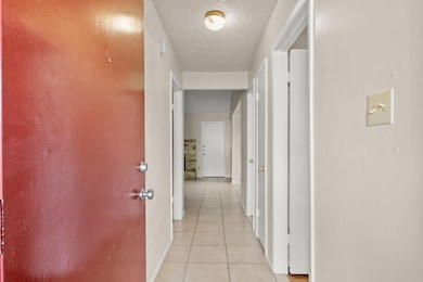 Corridor featuring light tile patterned flooring 