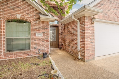 View of exterior entry with brick siding and a gar