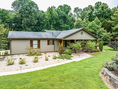 Ranch-style home with a front lawn, covered porch, and roof with shingles