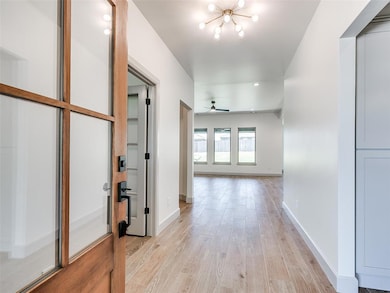 Entry - featuring unique light fixture, study to the left and living/kitchen straight ahead