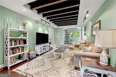 Living room featuring track lighting, baseboards, and wood finished floors